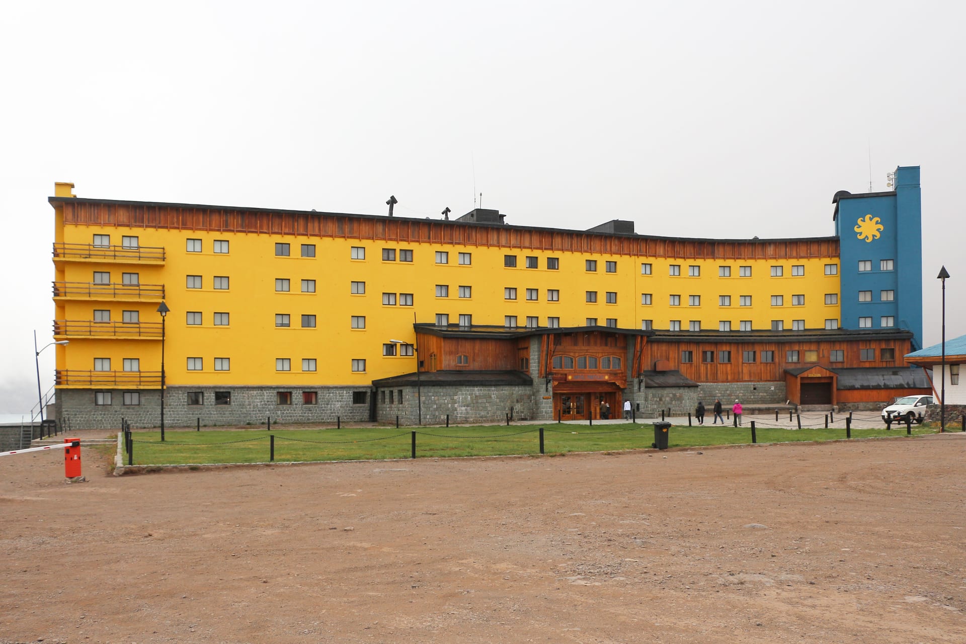 The yellow Portillo hotel below snowy slopes, beside the international route.